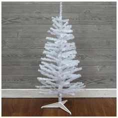 a white christmas tree on a wooden floor