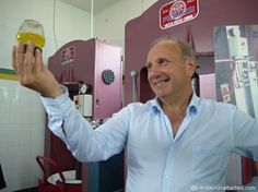 a man is holding up a glass of beer