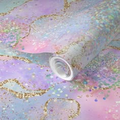 a pink and blue wallpaper with gold glitters on the ground, next to a roll of toilet paper