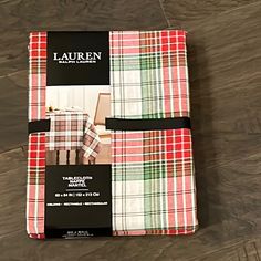 a book with plaid covers on top of a wooden floor next to a pair of scissors