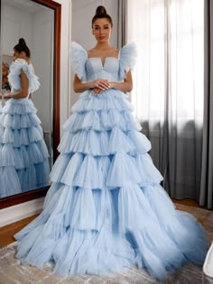 Step into a world of elegance and fantasy with this stunning sky blue Quinceanera ball gown. This dress is crafted from layers of pleated tulle that create an ethereal, flowing effect. The multi-tiered ruffles add volume and a playful, fairy-tale-like charm to your look. The V-neckline complements the sleeveless design, enhancing your natural beauty while maintaining a sophisticated appeal. The lace-up back ensures a perfect, secure fit, allowing you to feel confident and comfortable all night l Cloud Fairy, Debut Dress, 2022 Prom Dresses, Twirling Dress, Ruffle Prom Dress, Tulle Balls, Pleated Tulle, Tulle Ball Gown, Blue Tulle