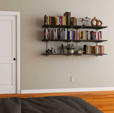 a bookshelf filled with lots of books on top of a wooden floor next to a white door