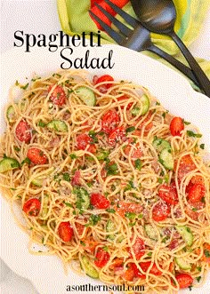 spaghetti salad with tomatoes and cucumbers on a white plate