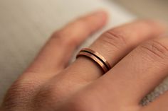 a close up of a person's hand with a wedding ring on their finger