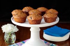 muffins on a cake stand with flowers in the background