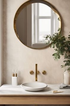 Modern bathroom with round mirror, gold faucet, white sink, and plant. Vanity Wall Ideas, Wooden Framed Mirror