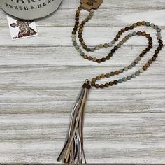 Embrace your bohemian spirit with our Boho Tribal Long Tassel Necklace. The unique and intricate design captures the essence of tribal artistry, making it a perfect accessory for your boho-chic outfits. No two of these necklaces are exactly alike, adding to their unique charm. Whether you're dressing up for a special event or simply adding a touch of elegance to your everyday wear, this necklace is sure to make a statement. Agate beads & leather tassel. Made in Paraguay. Long Tassel Necklace, Cowgirl Chic, Chic Necklace, Fringe Necklace, Boho Chic Outfits, Necklace Shop, Bead Leather, Leather Tassel, Agate Beads