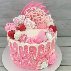 a pink cake with white frosting and hearts on top