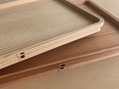 two wooden trays sitting on top of each other