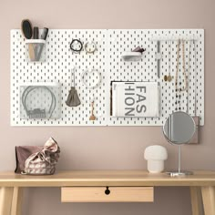 a wooden desk topped with a mirror next to a wall covered in jewelry and accessories