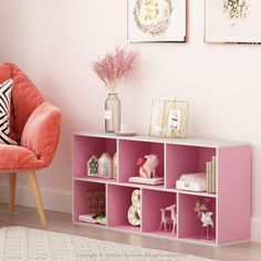 a pink chair sitting next to a shelf filled with figurines and other items