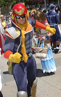 a man dressed in costume is walking down the street with other people behind him,