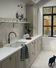 a kitchen with a sink, window and counter top in front of the stovetop