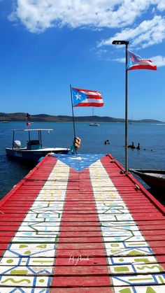 there is a boat that has been painted on the dock with flags flying from it