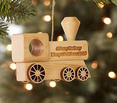 a wooden train ornament hanging from a christmas tree