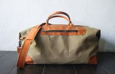 "Weekend bag or duffel bag perfect for overnight travel or extended weekends. This holdall is made in waxed canvas and leather mix. Great for anniversary gift for men and women. This bag is in creme colour canvas and tanned leather but available in many other colours, please check rest of my store for more colours. Perfect weekend bag or just over night travel. Or just for the gym in style. Bag made of creme coloured waxed canvas with tanned leather details. Lining in brown pinstripe. Our goal i Rectangular Waxed Duffle Bag For Weekend Trips, Rectangular Duffle Bag With Waxed Finish For Weekend Trips, Rectangular Waxed Finish Duffle Bag For Weekend Trips, Rectangular Waxed Finish Weekender Bag For Weekend Trips, Canvas Duffle Bag With Leather Handles For Trips, Rectangular Weekender Bag With Waxed Finish For Trips, Canvas Weekender Bag With Leather Handles For Trips, Handmade Anniversary Gift, Duffle Bag For Men