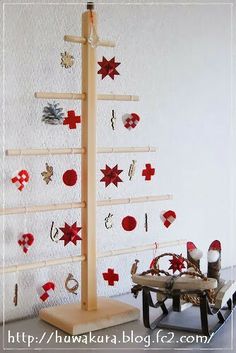 a christmas tree made out of wooden pegs and other decorations on a shelf in front of a white wall