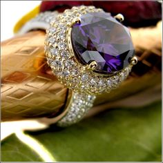 One of a kind exquisite ring set with AAA high quality oval amethyst color center stone in prong setting in 18K yellow gold top, domed band is covered with small pave set stones in platinum  StoneSize:  5ct. center 2ct. sides TCW 7 Stone Shape:  Oval/Round Metal:  18K Gold & Platinum Two Tone Luxury High Luster Oval Gemstones, Luxury Aaa Quality Women's Rings, Luxury Amethyst Ring With Diamond Accents And Cubic Zirconia, Luxury Macy's Ring With Center Stone, Luxury Oval Jewelry With Large Stone, Luxury Oval Crystal Ring With Large Stone, Luxury Oval Purple Diamond Ring, Luxury Oval Cabochon Birthstone Ring As Gift, Luxury Formal Rings With Large Stone