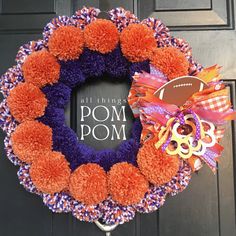 a purple and orange wreath with a football on it next to a sign that says pom pom