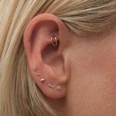 a close up of a person with ear piercings on their ears and behind the ear