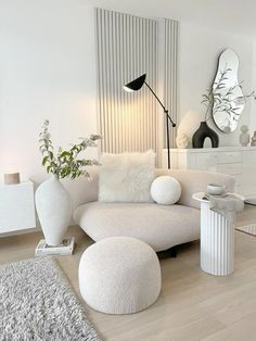 a living room filled with white furniture and decor