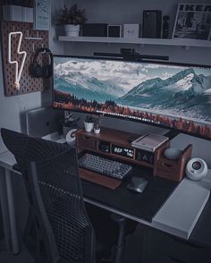 a computer desk with a monitor and keyboard on it in front of a wall mounted television