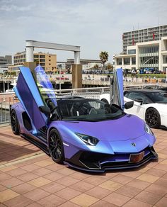 two cars parked next to each other in front of a parking lot with the doors open