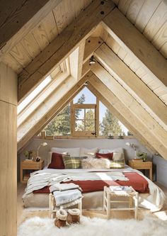 an attic bedroom with white sheepskin rugs on the floor and wooden beams in the ceiling