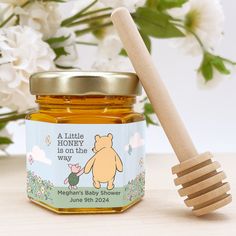 a honey jar with a wooden spoon next to it