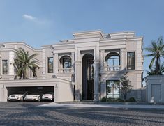 two cars are parked in front of a large white house with palm trees on either side