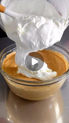 a glass bowl filled with whipped cream on top of a table