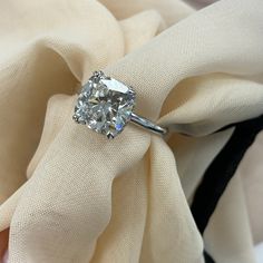 a cushion - cut diamond sits on top of a napkin