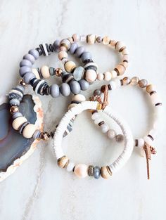 Earthy, natural, cozy, and everyday. Beautiful beige, white, cream, brown, and touches of sienna and rust in these mixed medium stack bracelets. Several gemstone varieties in different sizes, finishes, and colors. Several Agates, AA Labradorite, Pearls, Jasper, Gold Hematite, Riverstone, Fossilized Coral, Jade rondelle, and many ethical bone beads in a variety of colors and shapes. Mix these in with recycled glass, wood rondelle, Pave diamond wheel, shell, coconut disks, and mixed metals. Unique Bohemian White Bracelets For Everyday, White Earthy Everyday Jewelry, Earthy Everyday White Jewelry, Rustic Brown Beaded Bracelets For Everyday, Rustic Brown Beaded Bracelets For Everyday Wear, Rustic Handmade Beaded Bracelets For Everyday Wear, Stack Bracelets, Start Running, Fossilized Coral