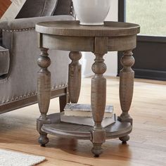 a wooden table sitting on top of a hard wood floor next to a gray couch