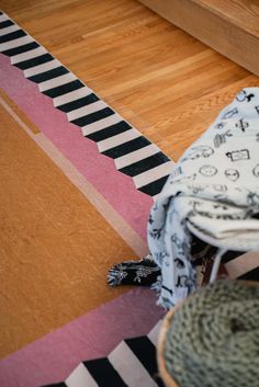 a cat is laying on the floor next to a blanket and some yarn in a basket