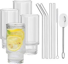 a set of four drinking glasses with straws next to each other on a white background