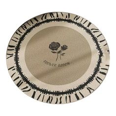 a black and white plate with a rose on the side, in front of a white background