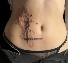 a woman's stomach with a cross tattoo on the side and stars around it