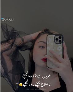 a woman holding up her cell phone in front of her face with an arabic quote on it