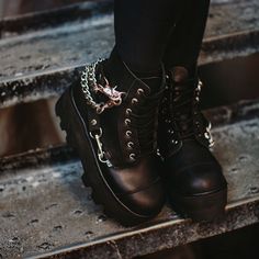 Normal is boring. Add some height to your day in these rad boots, featuring a cool, dino lug platform sole. Features a vegan friendly, black faux leather upper with a 7-eye lace-up closure. Has 4 removeable straps for some extra attitude. Has a sole height that is approximately 2 ¼” at the heel and 1 7/8” in the front. Has removable memory foam padding for added comfort. Trendy Moto Boots With Metal Feet For Streetwear, Grunge Platform Moto Boots For Streetwear, Trendy Streetwear Platform Boots With Metal Feet, Gothic Lace-up Boots With Lug Sole For Streetwear, Fall Streetwear Moto Boots With Metal Feet, Alternative Ankle Combat Boots For Streetwear, Trendy Moto Boots With Metal Feet For Alternative Fashion, Edgy Platform Boots With Lug Sole For Concert, Trendy Platform Boots With Metal Feet For Streetwear