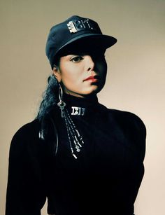 a woman with long hair wearing a hat and black dress is posing for the camera