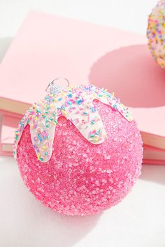 a pink ball with sprinkles and a bow on it