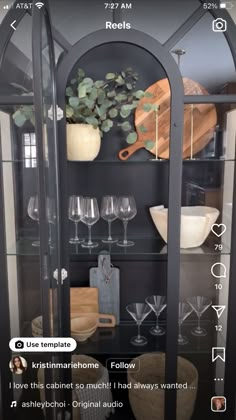 a display case with wine glasses and other items on the shelves in front of it