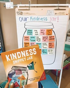 a person holding up a book in front of a whiteboard with words on it