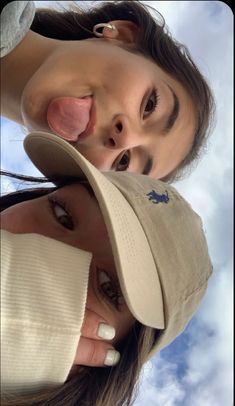 two women with hats on their heads are looking up into the sky and smiling at the camera