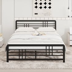 a bed with white sheets and black frame in a small room next to a window