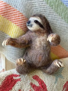 a small stuffed sloth sitting on top of a couch