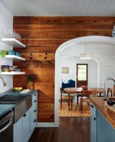 a kitchen with wooden walls and white cabinets