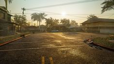 an empty parking lot in the middle of a residential area with palm trees on either side