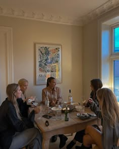 four women sitting at a table eating and drinking